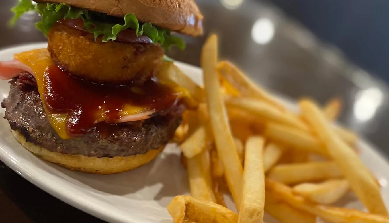 Burger with an onion ring and a side of fries at McNamara's Pub & Restaurant, Irish pub near Alexandria VA